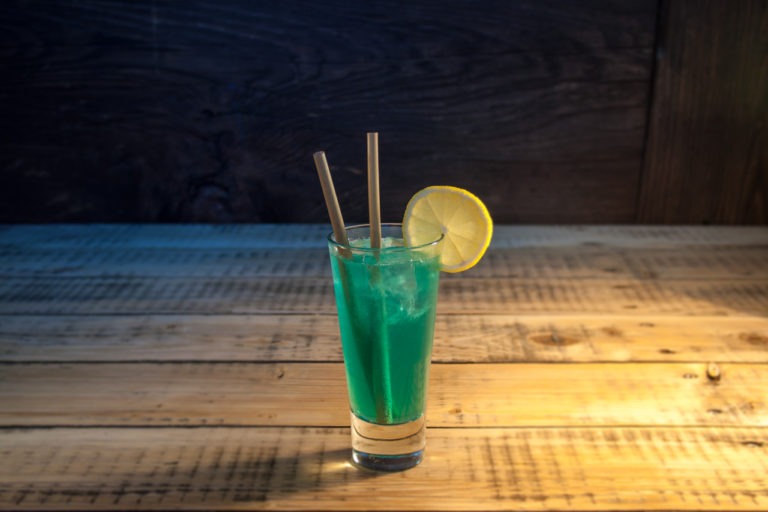 Cocktail Blue Lagoon in einem Glas mit Bambus Trinkhalm