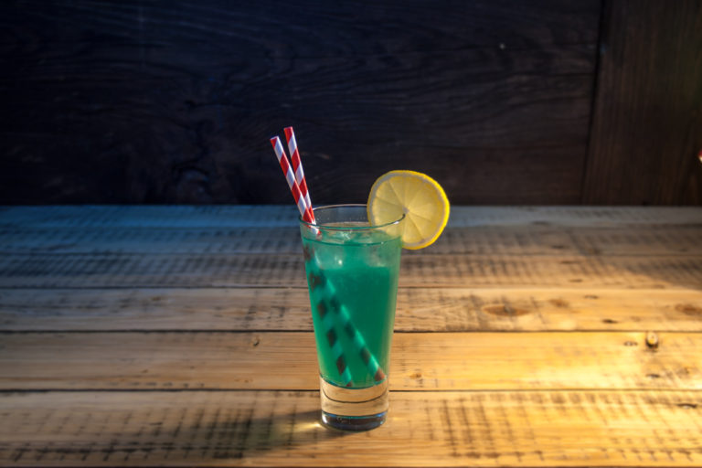 Cocktail Blue Lagoon in einem Glas mit Papier Trinkhalm