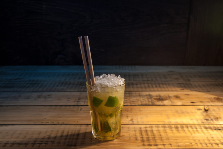 Cocktail Caipirinha in einem Glas mit Bambus Trinkhalm