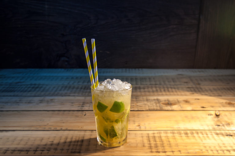 Cocktail Caipirinha in einem Glas mit Papier Trinkhalm